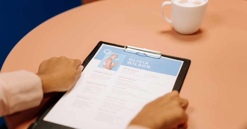 Close-up of hands holding resume during interview with coffee on table, highlighting workplace setting.